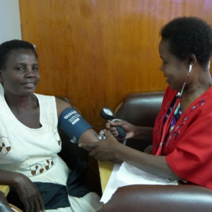 Malawian midwife measuring a pregnant mother's blood pressure